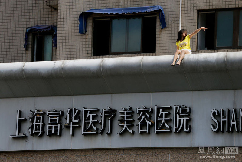 <em>上海</em>一名<em>女子</em>爬上<em>整形医院</em>楼顶做出危险举动,